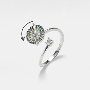 Silver saturn spinner ring with gemstones on a white background
