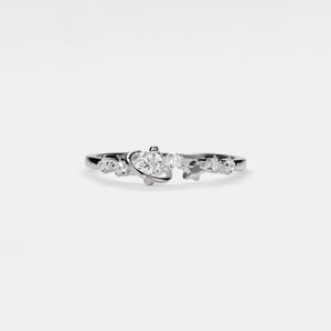 Silver ring with a heart-shaped center stone on a white background