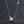 Silver necklace with a planet and star pendant on a dark textured background