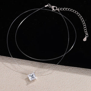 Silver necklace with a square pendant on a black and beige gradient background