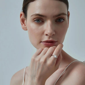 Woman wearing a diamond ring on a plain background