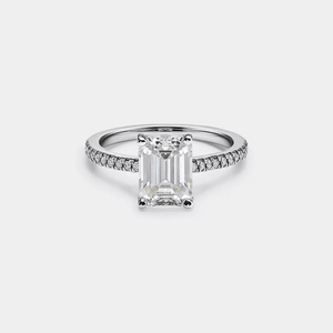 Diamond ring with a central emerald-cut diamond and smaller diamonds on the band against a light gray background