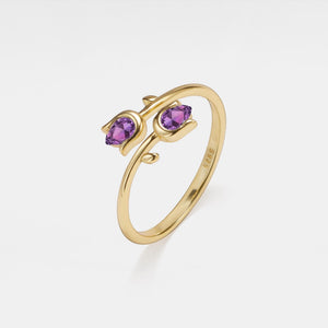 Gold ring with purple gemstones on a white background