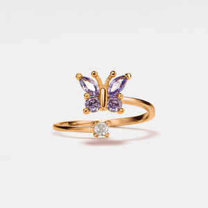 A gold-plated sterling silver ring with a bypass design featuring a butterfly motif and purple cubic zirconia stones.