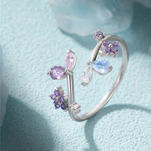 Silver ring with colorful gemstones on a light blue background