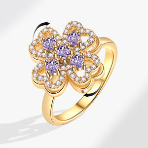 Gold ring with purple gemstones on a white background