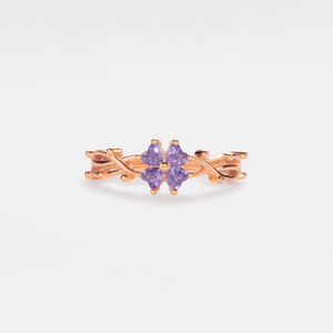A gold-plated sterling silver ring with a four-leaf clover design, featuring purple cubic zirconia.