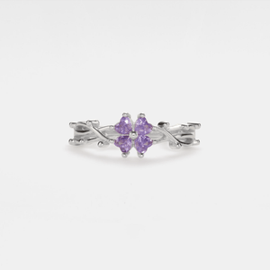 A gold-plated sterling silver ring with a four-leaf clover design, featuring purple cubic zirconia.
