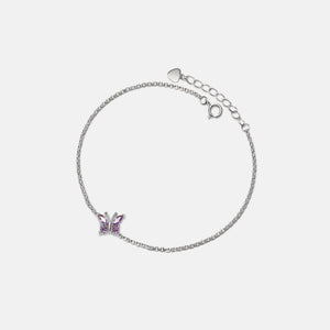 A gold-plated anklet with a charm depicting a butterfly, featuring a purple gemstone.