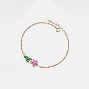 Gold bracelet with green and pink gemstones on a white background