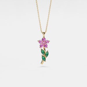 Gold necklace with a pink flower pendant on a white background