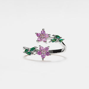 A gold-plated sterling silver bypass ring with purple and green cubic zirconia stones designed to resemble flowers, with an adjustable band.