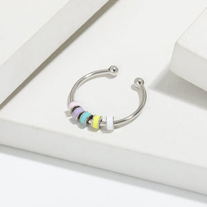 Adjustable sterling silver rings with multicolored enamel beads presented on a white box.