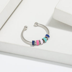 Adjustable sterling silver rings with multicolored enamel beads presented on a white box.