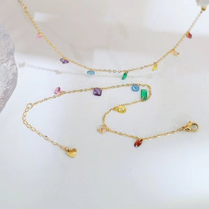 Gold bracelet with colorful gemstones on a white background