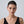 Woman wearing a black sleeveless top against a plain background