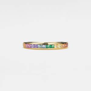 Gold ring with colorful gemstones on a light gray background