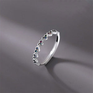 Silver ring with small gemstones on a gray background
