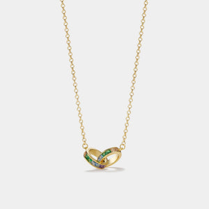 Gold necklace with a heart-shaped pendant on a light gray background