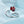 Silver ring with a red flower-shaped design on a light blue background