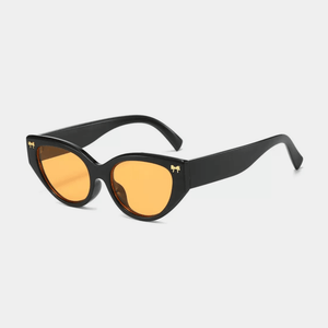 Black sunglasses with orange lenses on a light gray background