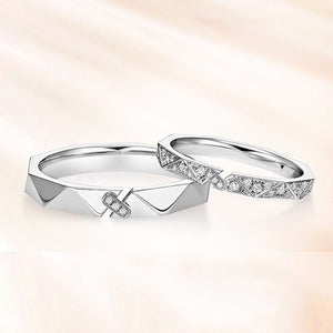 Two silver rings with geometric designs on a soft gradient background