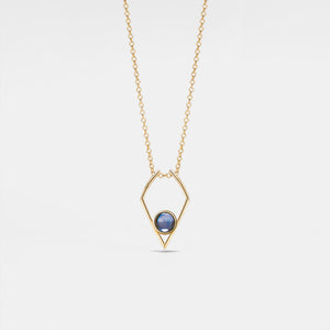 Gold necklace with a blue gemstone pendant on a light gray background