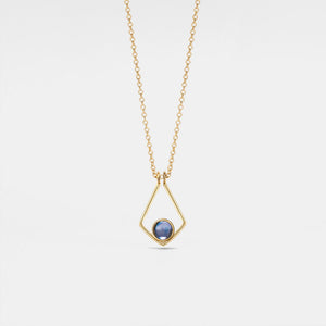 Gold necklace with a blue gemstone pendant on a light gray background
