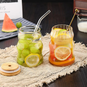 Two glass jars with fruit infusions on a textured surface.