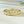 Gold ring with heart-shaped diamond stones on a light background