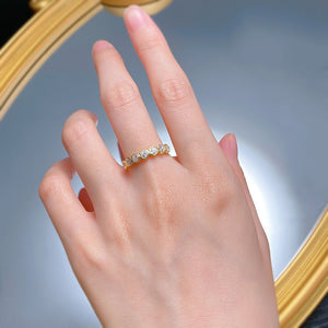 Hand wearing a diamond ring with a blurred background