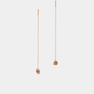 Rose gold threader earrings on a light gray background