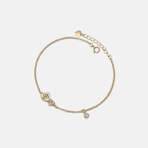 Gold bracelet with decorative elements on a light beige background