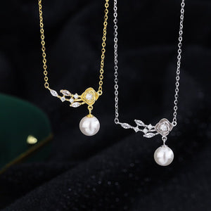 Two pearl necklaces, one gold and one silver, on a dark background.