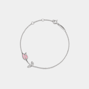A gold-plated sterling silver bracelet with a rose quartz tulip flower charm and cubic zirconia accents on a white background.