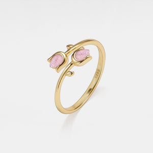 Gold ring with pink stones on a white background