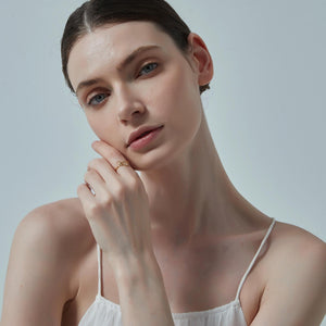 Woman wearing a white top against a light gray background