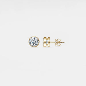 Gold diamond stud earrings on a light gray background