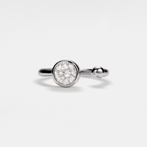 Silver ring with a round diamond on a light gray background