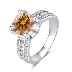 A collection of six moissanite cocktail rings with pave settings, displayed in a variety of colors including colorless, blue, yellow, red, and green.