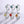 Set of six silver rings with colorful gemstones on a light gray background