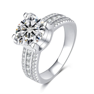 A collection of six moissanite cocktail rings with pave settings, displayed in a variety of colors including colorless, blue, yellow, red, and green.
