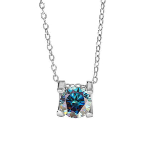 A round color moissanite pendant necklace with a red hue, set in a silver mounting on a chain.