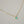 Gold necklace with a green gemstone on a light background