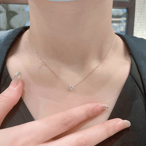 Necklace with a small pendant worn by a person, with a blurred background