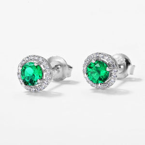 Pair of silver earrings with green gemstones on a white background