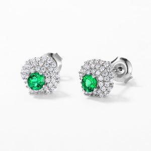 Pair of emerald and diamond stud earrings on a white background