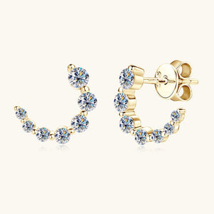Gold earrings with clear gemstones on a white background