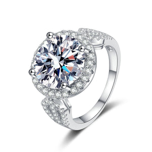 Silver ring with a large central gemstone and smaller stones on a white background