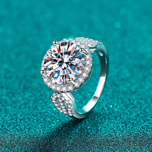 Silver ring with a large diamond on a teal background